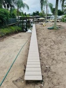 Composite board topped seawall installation next to natural boat ramp