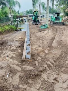 Buried vinyl seawall installation along a sloped natural boat ramp